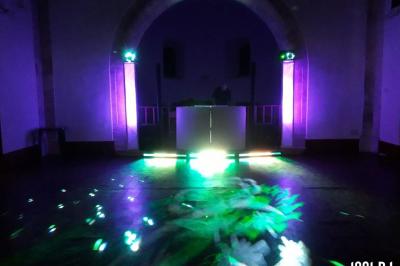 Un couple de mariés s'embrasse sous une haie d'honneur formée par des pompiers tenant des roses rouges.