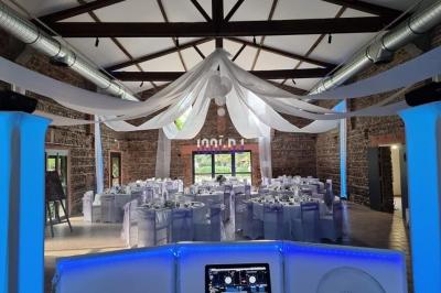 Un couple de mariés s'embrasse sous une haie d'honneur formée par des pompiers tenant des roses rouges.