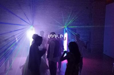 Un couple de mariés s'embrasse sous une haie d'honneur formée par des pompiers tenant des roses rouges.