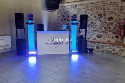 Un couple de mariés s'embrasse sous une haie d'honneur formée par des pompiers tenant des roses rouges.