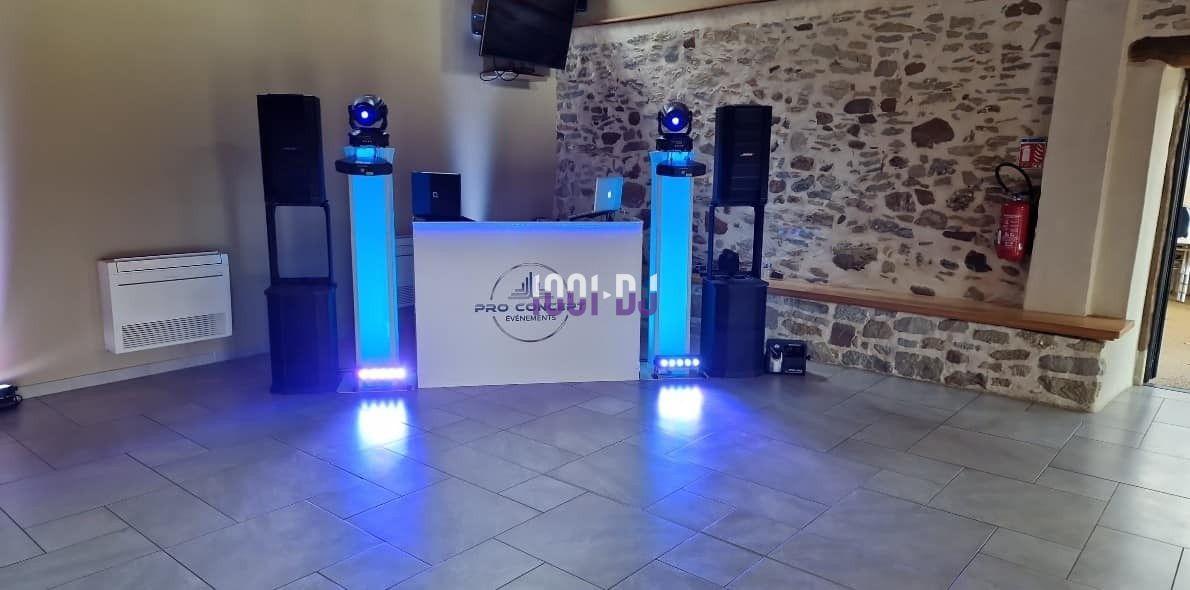 Installation de matériel de sonorisation et éclairage avec une table de mixage dans une salle aux murs en pierre.