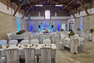 Un couple de mariés s'embrasse sous une haie d'honneur formée par des pompiers tenant des roses rouges.