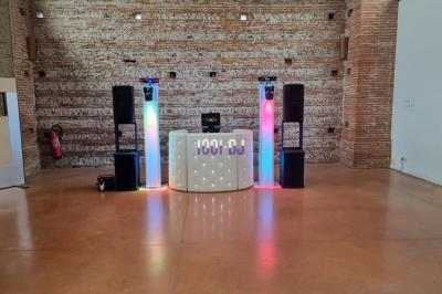 Un couple de mariés s'embrasse sous une haie d'honneur formée par des pompiers tenant des roses rouges.