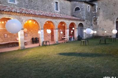 Vieille tour en briques rouges avec des fenêtres, entourée de végétation et d'un ciel bleu clair.