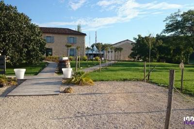 Vieille tour en briques rouges avec des fenêtres, entourée de végétation et d'un ciel bleu clair.