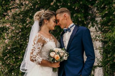 Une mariée glisse une alliance au doigt de son partenaire lors d'une cérémonie de mariage.