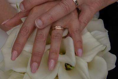 Une mariée glisse une alliance au doigt de son partenaire lors d'une cérémonie de mariage.