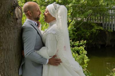 Une mariée glisse une alliance au doigt de son partenaire lors d'une cérémonie de mariage.