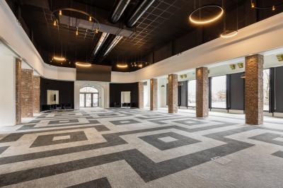 Façade moderne d'un hôtel Mercure avec des voitures circulant devant, entouré d'arbres et d'un ciel partiellement nuageux.