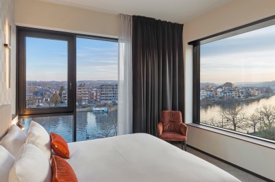 Miniature Location salle Namur (Province de Namur) - Casino Resort Namur #20 Vue sur une rivière bordée de bateaux, avec des bâtiments historiques et une colline boisée en arrière-plan.