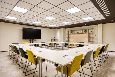 Terrasse moderne avec mobilier vert et blanc, vue sur une rivière et des bâtiments en arrière-plan.