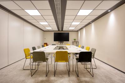 Terrasse moderne avec mobilier vert et blanc, vue sur une rivière et des bâtiments en arrière-plan.