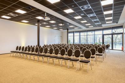 Terrasse moderne avec mobilier vert et blanc, vue sur une rivière et des bâtiments en arrière-plan.
