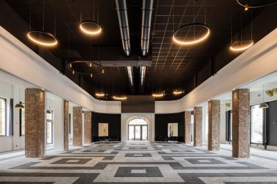 Terrasse moderne avec mobilier vert et blanc, vue sur une rivière et des bâtiments en arrière-plan.