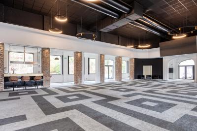 Terrasse moderne avec mobilier vert et blanc, vue sur une rivière et des bâtiments en arrière-plan.