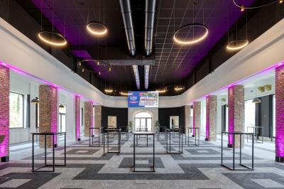 Terrasse moderne avec mobilier vert et blanc, vue sur une rivière et des bâtiments en arrière-plan.