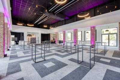 Terrasse moderne avec mobilier vert et blanc, vue sur une rivière et des bâtiments en arrière-plan.