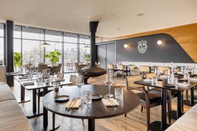 Terrasse moderne avec mobilier vert et blanc, vue sur une rivière et des bâtiments en arrière-plan.