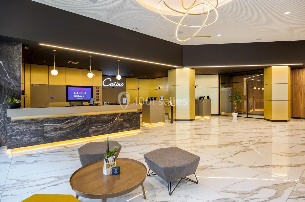 Hall d'entrée moderne avec comptoirs d'accueil, sol en marbre, éclairage design et mobilier contemporain.