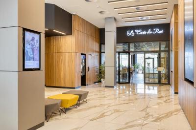 Terrasse moderne avec mobilier vert et blanc, vue sur une rivière et des bâtiments en arrière-plan.
