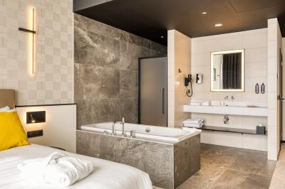 Terrasse moderne avec mobilier vert et blanc, vue sur une rivière et des bâtiments en arrière-plan.