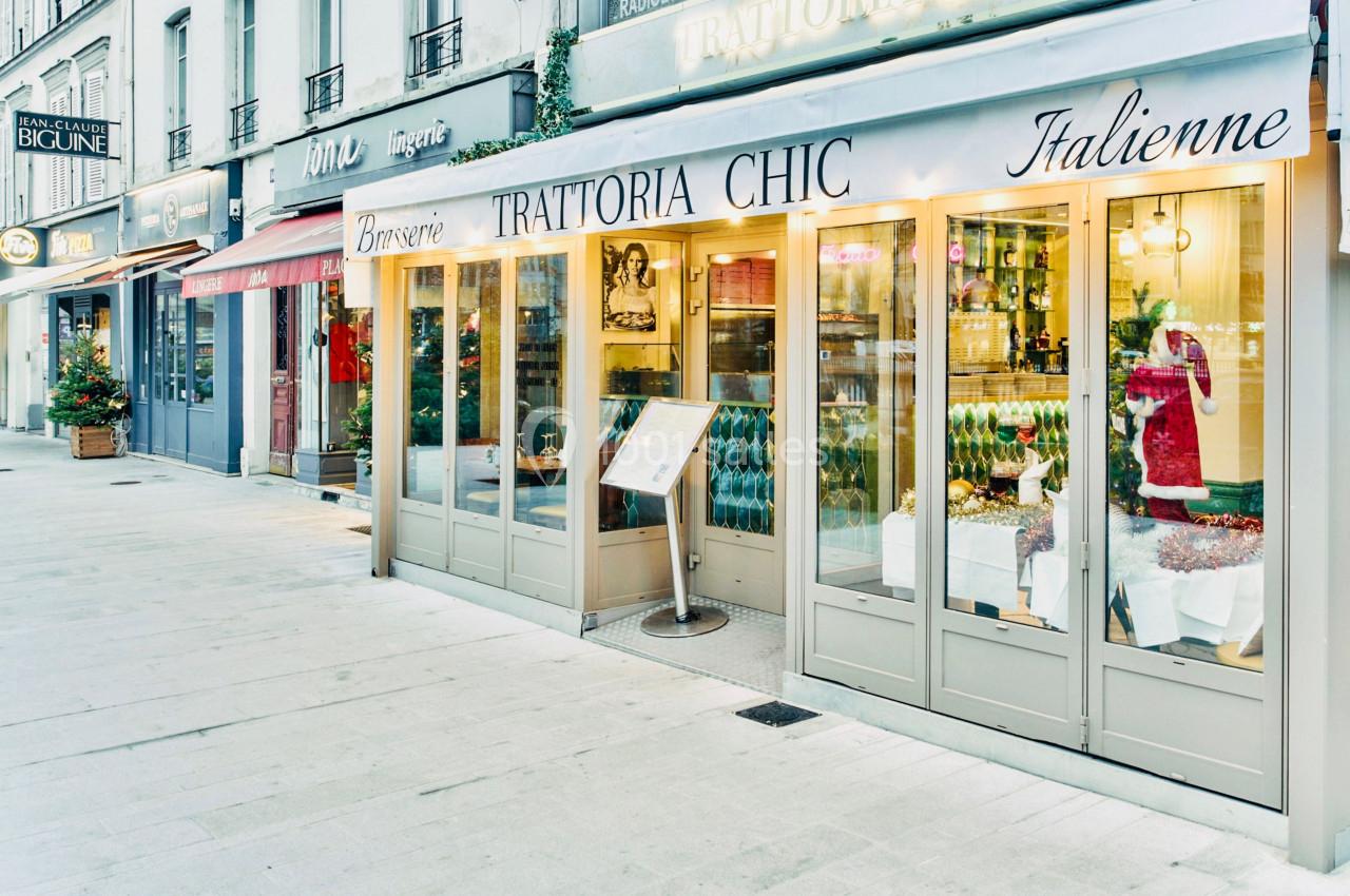 Façade d'une brasserie italienne avec une devanture vitrée et une terrasse dans une rue commerçante.