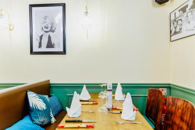 Façade d'un restaurant italien avec vitrines éclairées, menu extérieur et décorations de Noël sur le trottoir.