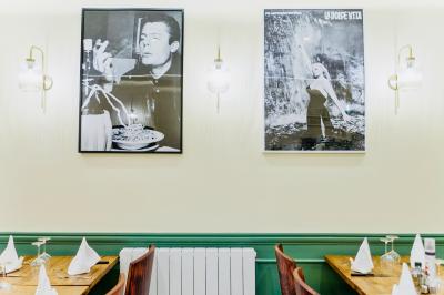 Façade d'un restaurant italien avec vitrines éclairées, menu extérieur et décorations de Noël sur le trottoir.