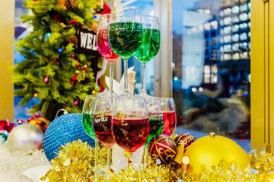 Façade d'un restaurant italien avec vitrines éclairées, menu extérieur et décorations de Noël sur le trottoir.