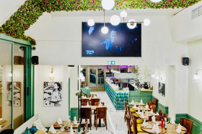 Façade d'un restaurant italien avec vitrines éclairées, menu extérieur et décorations de Noël sur le trottoir.