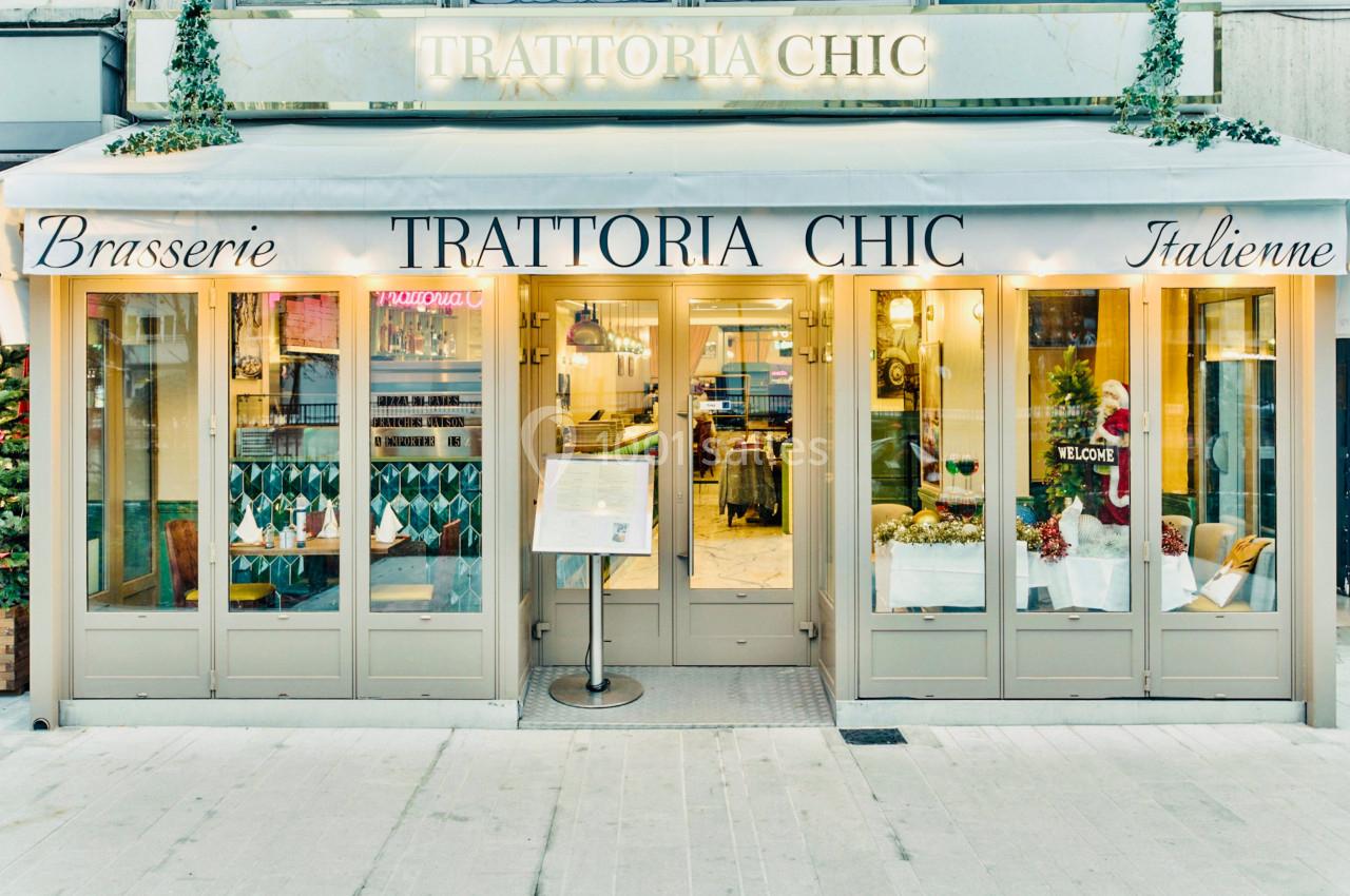 Façade d'un restaurant italien avec terrasse couverte, enseigne ’Trattoria Chic’ et menu affiché à l'entrée.