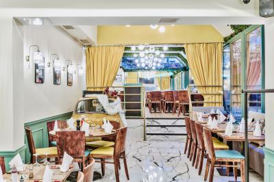 Façade d'un restaurant italien avec vitrines éclairées, menu extérieur et décorations de Noël sur le trottoir.