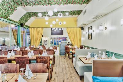 Façade d'un restaurant italien avec vitrines éclairées, menu extérieur et décorations de Noël sur le trottoir.