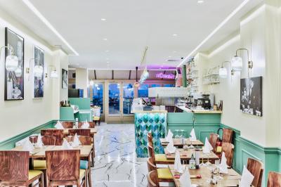 Façade d'un restaurant italien avec vitrines éclairées, menu extérieur et décorations de Noël sur le trottoir.