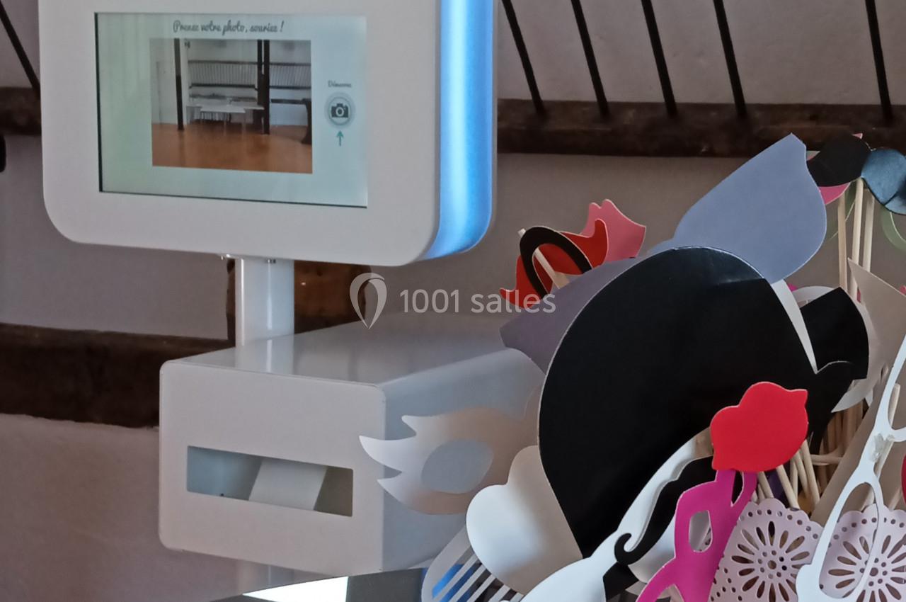 Borne photo interactive avec accessoires colorés sur une table, décorée pour un événement festif.