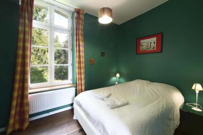Salle de réception élégante avec tables dressées, chaises blanches, décorations florales et un piano en arrière-plan.