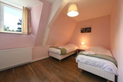 Salle de réception élégante avec tables dressées, chaises blanches, décorations florales et un piano en arrière-plan.