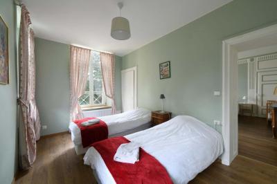 Salle de réception élégante avec tables dressées, chaises blanches, décorations florales et un piano en arrière-plan.