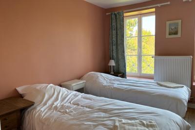 Salle de réception élégante avec tables dressées, chaises blanches, décorations florales et un piano en arrière-plan.