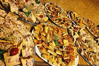 Plateaux garnis de toasts variés, avec fromage gratiné, pâté et décorations de tomates cerises et herbes fraîches.