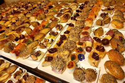 Plateaux garnis de toasts variés, avec fromage gratiné, pâté et décorations de tomates cerises et herbes fraîches.