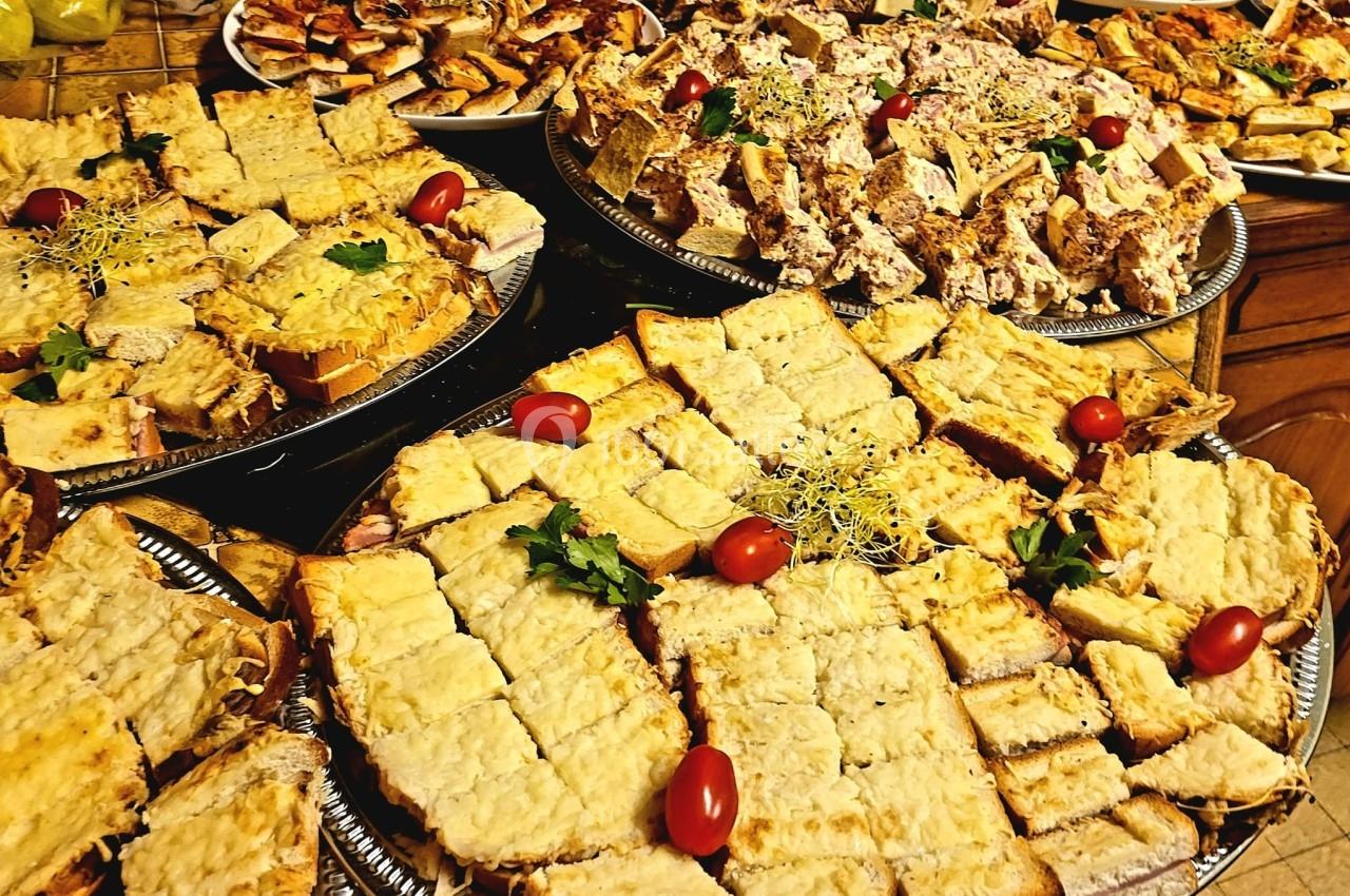 Plateaux garnis de toasts variés, avec fromage gratiné, pâté et décorations de tomates cerises et herbes fraîches.