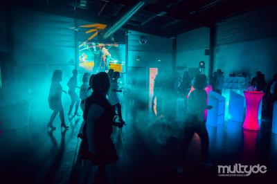 Terrasse extérieure avec tables, chaises et parasols, située près d'un bâtiment moderne et d'un espace vert.