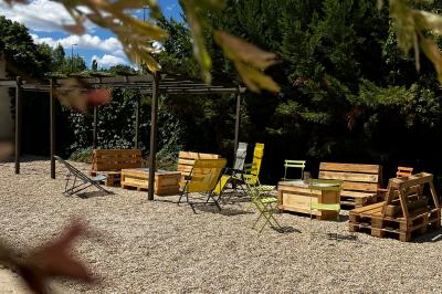 Banderole rouge annonçant l'ouverture d'un café, accrochée à une clôture en bois près d'un portail vert.