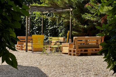 Banderole rouge annonçant l'ouverture d'un café, accrochée à une clôture en bois près d'un portail vert.