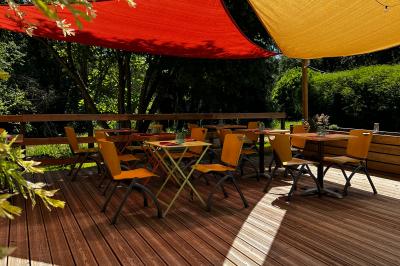 Banderole rouge annonçant l'ouverture d'un café, accrochée à une clôture en bois près d'un portail vert.