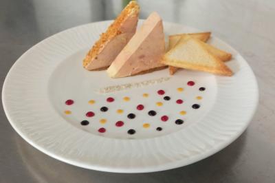Plateau de verrines et amuse-bouches colorés disposés sur une planche en bois, en extérieur sur une pelouse.
