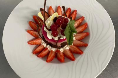 Plateau de verrines et amuse-bouches colorés disposés sur une planche en bois, en extérieur sur une pelouse.