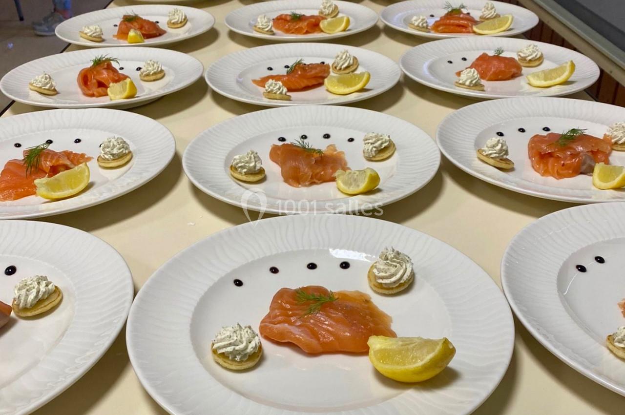 Assiettes dressées avec saumon fumé, blinis, crème, citron et décoration de points de sauce balsamique.