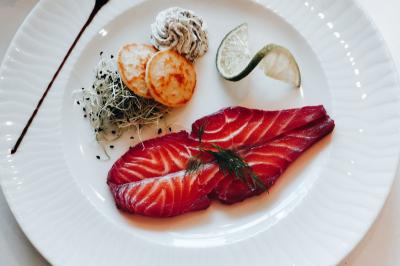 Plateau de verrines et amuse-bouches colorés disposés sur une planche en bois, en extérieur sur une pelouse.
